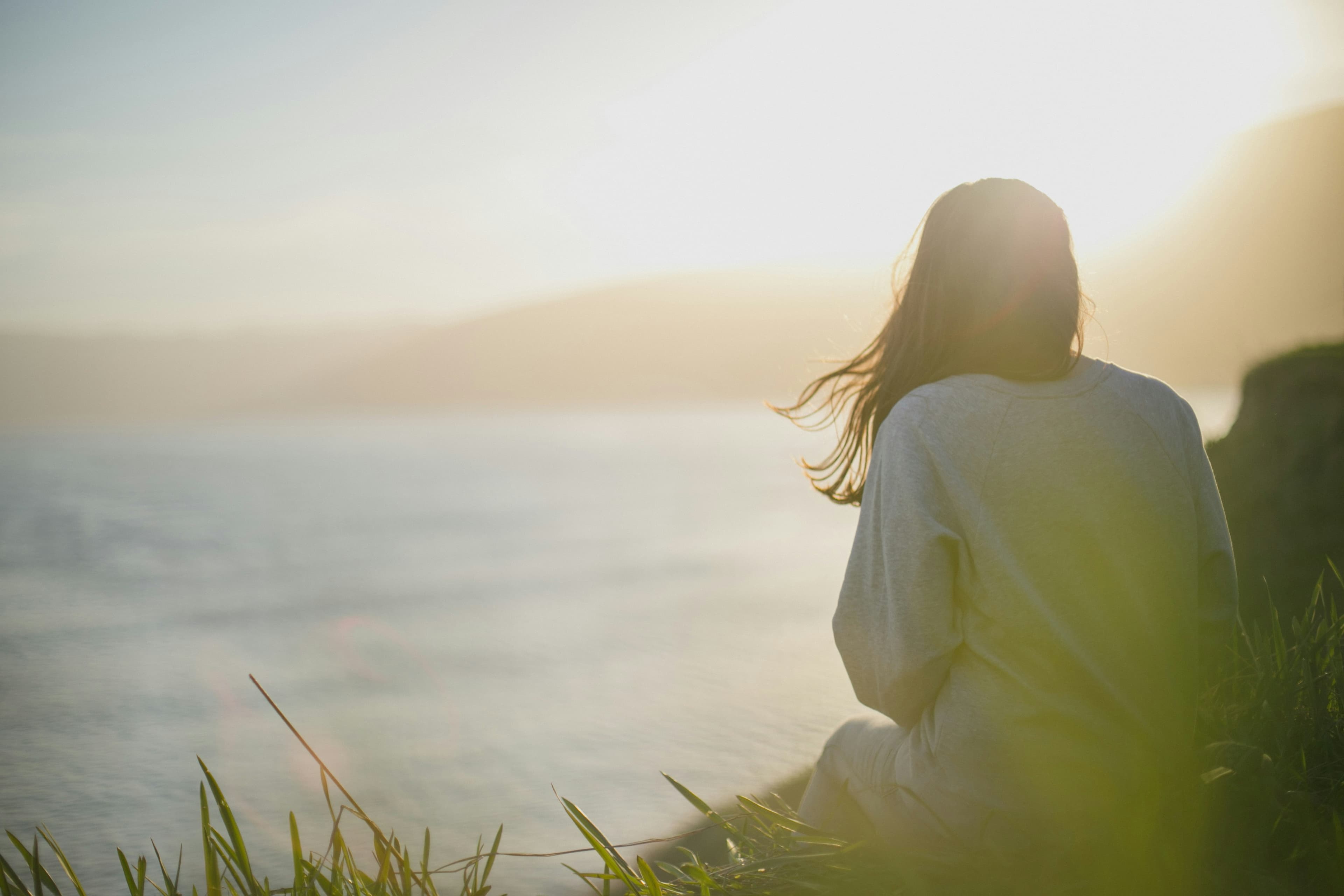 Mujer de espaldas contemplando un paisaje amplio